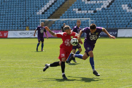 ODESSA, UKRAINE - aug 24, 2021: Football. Traditional Cup of Ukraine among ATO veterans. Veterans play football on green lawn of stadium. Game moment of football fight for cup. Vivid emotions of gameのeditorial素材