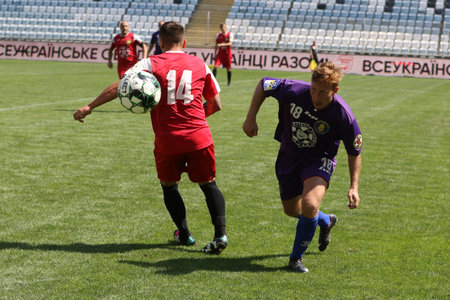 ODESSA, UKRAINE - aug 24, 2021: Football. Traditional Cup of Ukraine among ATO veterans. Veterans play football on green lawn of stadium. Game moment of football fight for cup. Vivid emotions of gameのeditorial素材