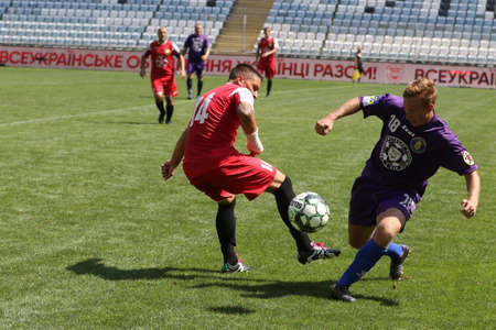 ODESSA, UKRAINE - aug 24, 2021: Football. Traditional Cup of Ukraine among ATO veterans. Veterans play football on green lawn of stadium. Game moment of football fight for cup. Vivid emotions of gameのeditorial素材