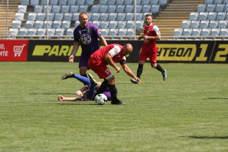 ODESSA, UKRAINE - aug 24, 2021: Football. Traditional Cup of Ukraine among ATO veterans. Veterans play football on green lawn of stadium. Game moment of football fight for cup. Vivid emotions of gameのeditorial素材
