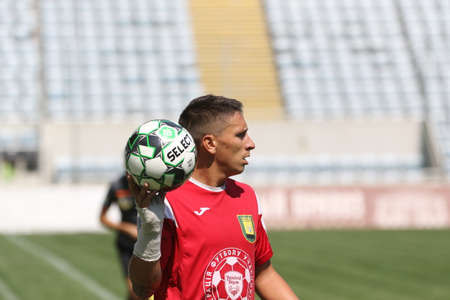 ODESSA, UKRAINE - aug 24, 2021: Football. Traditional Cup of Ukraine among ATO veterans. Veterans play football on green lawn of stadium. Game moment of football fight for cup. Vivid emotions of gameのeditorial素材