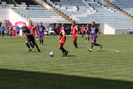ODESSA, UKRAINE - aug 24, 2021: Football. Traditional Cup of Ukraine among ATO veterans. Veterans play football on green lawn of stadium. Game moment of football fight for cup. Vivid emotions of gameのeditorial素材
