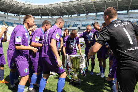 ODESSA, UKRAINE - aug 24, 2021: Football. Traditional Cup of Ukraine among ATO veterans. Veterans play football on green lawn of stadium. Game moment of football fight for cup. Vivid emotions of gameのeditorial素材