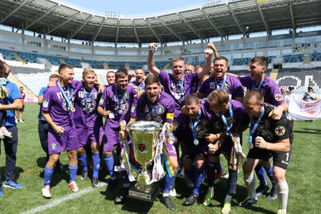 ODESSA, UKRAINE - aug 24, 2021: Football. Traditional Cup of Ukraine among ATO veterans. Veterans play football on green lawn of stadium. Game moment of football fight for cup. Vivid emotions of game
