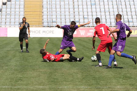 ODESSA, UKRAINE - aug 24, 2021: Football. Traditional Cup of Ukraine among ATO veterans. Veterans play football on green lawn of stadium. Game moment of football fight for cup. Vivid emotions of gameのeditorial素材
