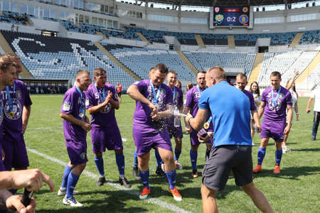ODESSA, UKRAINE - aug 24, 2021: Football. Traditional Cup of Ukraine among ATO veterans. Veterans play football on green lawn of stadium. Game moment of football fight for cup. Vivid emotions of gameのeditorial素材