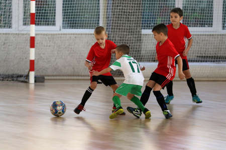 ODESSA, UKRAINE - oct 14, 2021: Little boys 8-9 years, children play mini-football in sports hall at Ukrainian Championship. Children's sports are healthy lifestyle. Boy sport soccer players futsalのeditorial素材