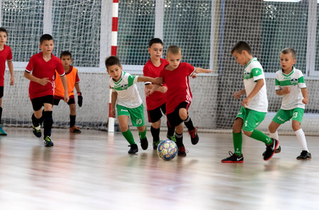 ODESSA, UKRAINE - oct 14, 2021: Little boys 8-9 years, children play mini-football in sports hall at Ukrainian Championship. Children's sports are healthy lifestyle. Boy sport soccer players futsalのeditorial素材