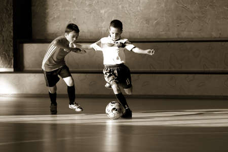 ODESSA, UKRAINE - oct 14, 2021: Little boys 8-9 years, children play mini-football in sports hall at Ukrainian Championship. Children's sports are healthy lifestyle. Boy sport soccer players futsalのeditorial素材