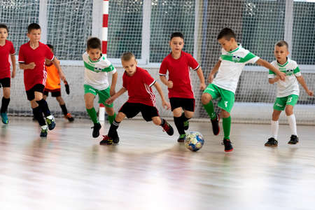 ODESSA, UKRAINE - oct 14, 2021: Little boys 8-9 years, children play mini-football in sports hall at Ukrainian Championship. Children's sports are healthy lifestyle. Boy sport soccer players futsalのeditorial素材