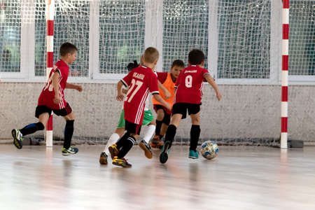 ODESSA, UKRAINE - oct 14, 2021: Little boys 8-9 years, children play mini-football in sports hall at Ukrainian Championship. Children's sports are healthy lifestyle. Boy sport soccer players futsalのeditorial素材