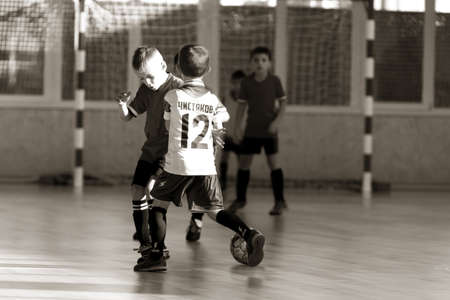 ODESSA, UKRAINE - oct 14, 2021: Little boys 8-9 years, children play mini-football in sports hall at Ukrainian Championship. Children's sports are healthy lifestyle. Boy sport soccer players futsalのeditorial素材