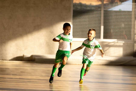 ODESSA, UKRAINE - oct 14, 2021: Little boys 8-9 years, children play mini-football in sports hall at Ukrainian Championship. Children's sports are healthy lifestyle. Boy sport soccer players futsalのeditorial素材