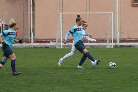 ODESSA, UKRAINE -31 DECEMBER 2021: Women's football on grass field of stadium. Football Championship among women White - FC Chernomorets Odessa - Yunost Chernigov. Game moment of girls footballのeditorial素材