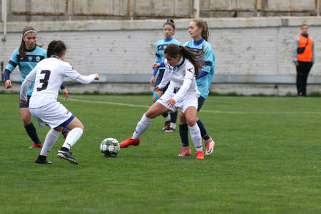 ODESSA, UKRAINE -31 DECEMBER 2021: Women's football on grass field of stadium. Football Championship among women White - FC Chernomorets Odessa - Yunost Chernigov. Game moment of girls footballのeditorial素材