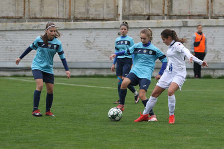 ODESSA, UKRAINE -31 DECEMBER 2021: Women's football on grass field of stadium. Football Championship among women White - FC Chernomorets Odessa - Yunost Chernigov. Game moment of girls footballのeditorial素材