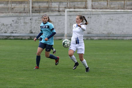 ODESSA, UKRAINE -31 DECEMBER 2021: Women's football on grass field of stadium. Football Championship among women White - FC Chernomorets Odessa - Yunost Chernigov. Game moment of girls footballのeditorial素材