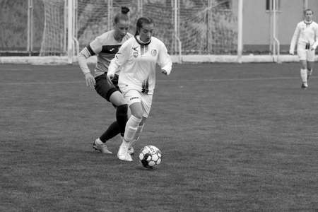 ODESSA, UKRAINE -31 DECEMBER 2021: Women's football on grass field of stadium. Football Championship among women White - FC Chernomorets Odessa - Yunost Chernigov. Game moment of girls footballのeditorial素材