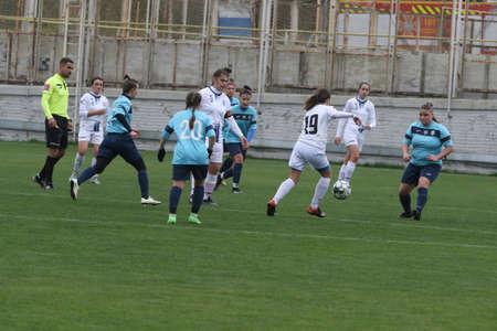 ODESSA, UKRAINE -31 DECEMBER 2021: Women's football on grass field of stadium. Football Championship among women White - FC Chernomorets Odessa - Yunost Chernigov. Game moment of girls footballのeditorial素材