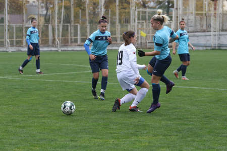 ODESSA, UKRAINE -31 DECEMBER 2021: Women's football on grass field of stadium. Football Championship among women White - FC Chernomorets Odessa - Yunost Chernigov. Game moment of girls footballのeditorial素材