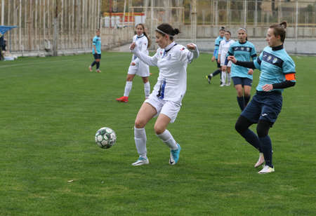 ODESSA, UKRAINE -31 DECEMBER 2021: Women's football on grass field of stadium. Football Championship among women White - FC Chernomorets Odessa - Yunost Chernigov. Game moment of girls footballのeditorial素材
