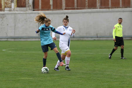 ODESSA, UKRAINE -31 DECEMBER 2021: Women's football on grass field of stadium. Football Championship among women White - FC Chernomorets Odessa - Yunost Chernigov. Game moment of girls footballのeditorial素材