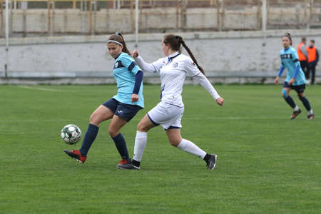 ODESSA, UKRAINE -31 DECEMBER 2021: Women's football on grass field of stadium. Football Championship among women White - FC Chernomorets Odessa - Yunost Chernigov. Game moment of girls footballのeditorial素材