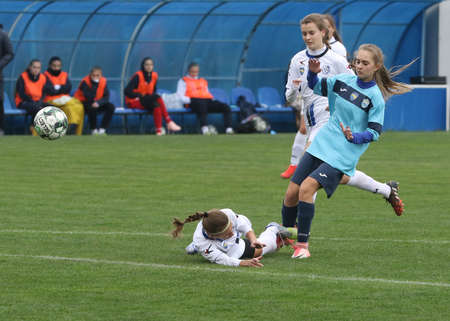 ODESSA, UKRAINE -31 DECEMBER 2021: Women's football on grass field of stadium. Football Championship among women White - FC Chernomorets Odessa - Yunost Chernigov. Game moment of girls footballのeditorial素材
