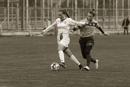 ODESSA, UKRAINE -31 DECEMBER 2021: Women's football on grass field of stadium. Football Championship among women White - FC Chernomorets Odessa - Yunost Chernigov. Game moment of girls footballのeditorial素材