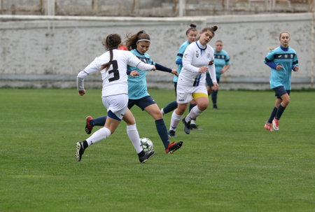 ODESSA, UKRAINE -31 DECEMBER 2021: Women's football on grass field of stadium. Football Championship among women White - FC Chernomorets Odessa - Yunost Chernigov. Game moment of girls footballのeditorial素材