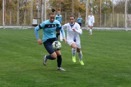 ODESSA, UKRAINE -31 DECEMBER 2021: Women's football on grass field of stadium. Football Championship among women White - FC Chernomorets Odessa - Yunost Chernigov. Game moment of girls footballのeditorial素材