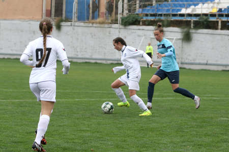 ODESSA, UKRAINE -31 DECEMBER 2021: Women's football on grass field of stadium. Football Championship among women White - FC Chernomorets Odessa - Yunost Chernigov. Game moment of girls footballのeditorial素材