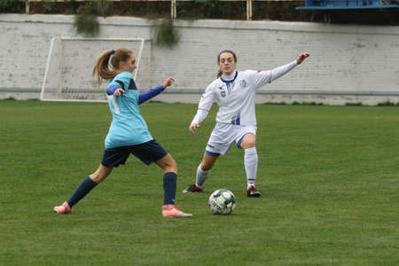 ODESSA, UKRAINE -31 DECEMBER 2021: Women's football on grass field of stadium. Football Championship among women White - FC Chernomorets Odessa - Yunost Chernigov. Game moment of girls footballのeditorial素材