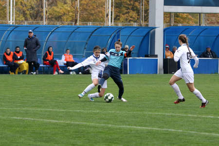 ODESSA, UKRAINE -31 DECEMBER 2021: Women's football on grass field of stadium. Football Championship among women White - FC Chernomorets Odessa - Yunost Chernigov. Game moment of girls footballのeditorial素材