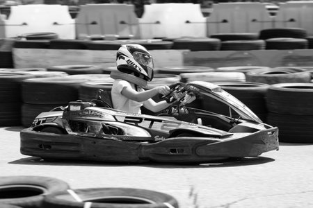 ODESSA, UKRAINE - June 18, 2022: Karting. Go Kart on track. Young positive girl racer in a helmet driving kart during car race on an auto track outdoors. extreme auto sport in sports clubのeditorial素材