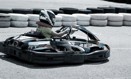 ODESSA, UKRAINE - June 18, 2022: Karting. Go Kart on track. Young positive girl racer in a helmet driving kart during car race on an auto track outdoors. extreme auto sport in sports clubのeditorial素材
