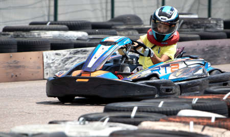 ODESSA, UKRAINE - June 18, 2022: Karting. Go Kart on track. Young positive girl racer in a helmet driving kart during car race on an auto track outdoors. extreme auto sport in sports clubのeditorial素材