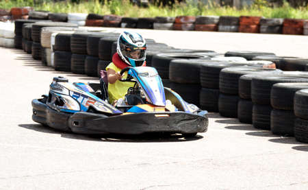 ODESSA, UKRAINE - June 18, 2022: Karting. Go Kart on track. Young positive girl racer in a helmet...