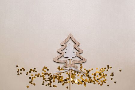 Christmas tree made of wood and stars confetti on gold table top view.の写真素材
