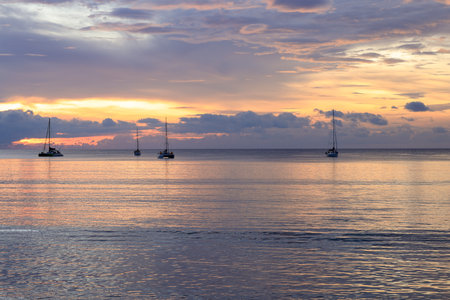 Magical sun setting on the beach of Naiyang on the island of Phuket in Thailand.の写真素材