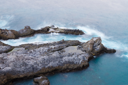 Long exposure view of rocky coastline with deep blue sea water. Tenerife, Canary islandsの写真素材