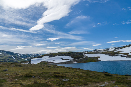 Road in summer snow highland under blue skyの写真素材