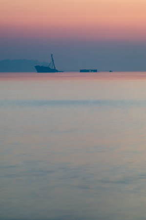 Partially sunken ship in after sunset hazeの写真素材