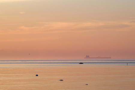 Cargo ship in blue water haze after sunsetの写真素材