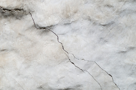 Old concrete wall with diagonal crackの写真素材