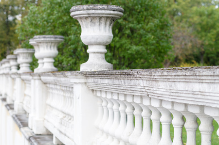 Ancient concrete fence with decorative bowls, diminishing perspective