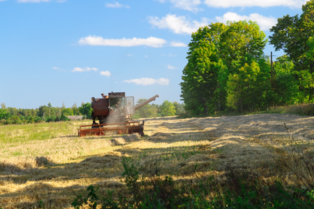 Old soviet combine harvester working in a field, harvest time conceptの写真素材