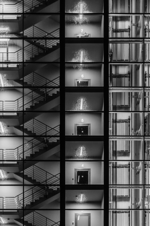 Abstract exterior of modern building. Staircase, lift and stairwell through transparent glass. Black and white conceptの写真素材