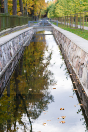Defocused image of canal with autumnal trees reflection in water, Kadriorg park, Tallinn, Estoniaの写真素材