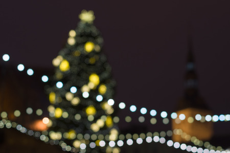 Abstract blurred background of decorated Christmas fir on central city squareの写真素材